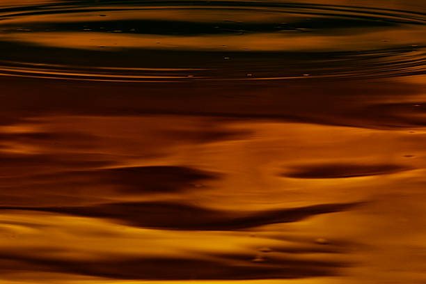 Coffee colored liquid Photograph of the surface of a colored liquid traversed by waves and wavelets aquatint stock pictures, royalty-free photos & images