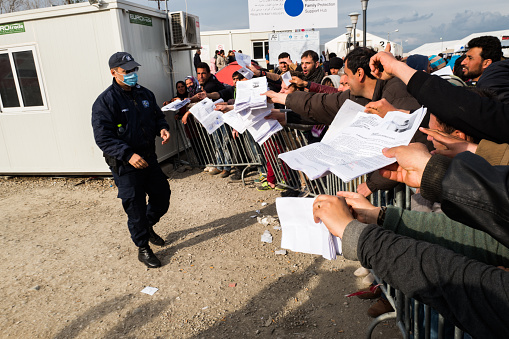 Idomeni, Greece - March 3, 2016: Refugees waiting to have their paperwork sorted in Idomeni refugee camp. Borders with Former Yugoslavic Republic of Macedonia. 12000 immigrants are in a wait at the border between Greece and FYROM waiting for the right time to continue their journey from unguarded passages. The borders have been closed and guarded against immigrants passing.