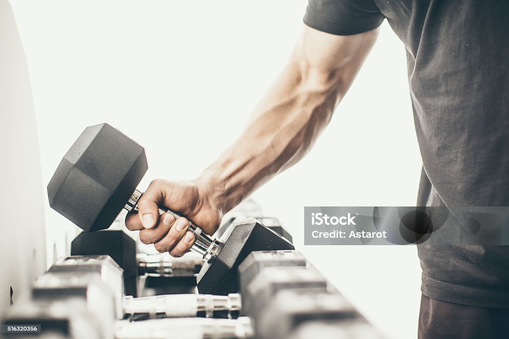 Gym Unrecognizable man taking dumbbells in a gym Body Building Stock Photo