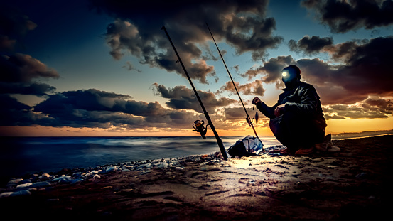 Fishing on coast at sunset time