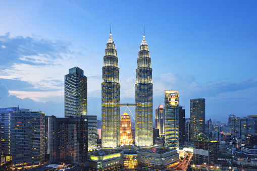 Kuala Lumpur Petronas Towers at sunset in blue sky background, Malaysia.