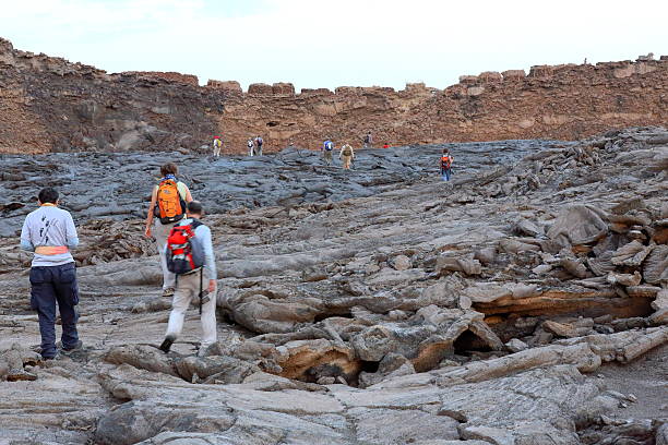 Danakil, Ethiopia-March 27, 2013: Tourists walk the solid lava field-caldera of world longest existing burning lava lake-since 1906-Erta Ale volcano-613 ms.high-0.7 x 1.6 km.elliptic crater on March 27, 2013.
