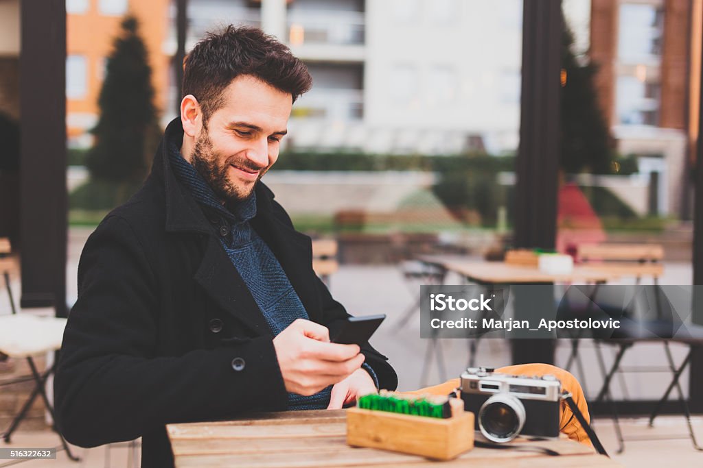 Young man texting Young man using smartphone in the cafe Adult Stock Photo