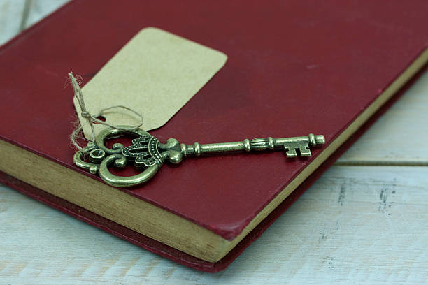 istock Old keys and book on a rustic background 516323222