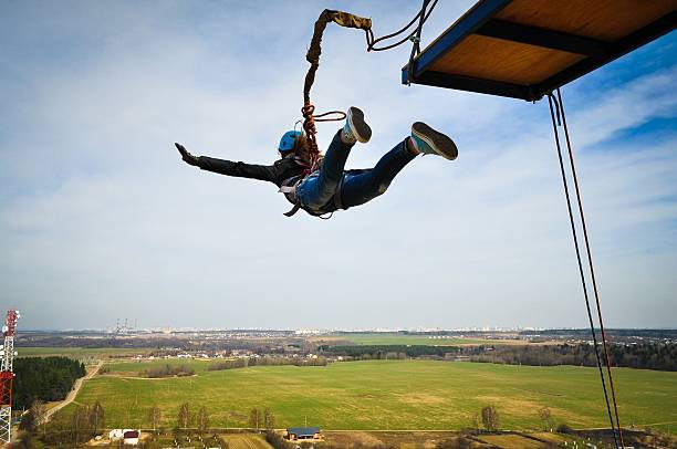 Ropejumping Ropejumping: girl jumping from a height in the equipment for mountaineering and helmet bungee jumping stock pictures, royalty-free photos & images