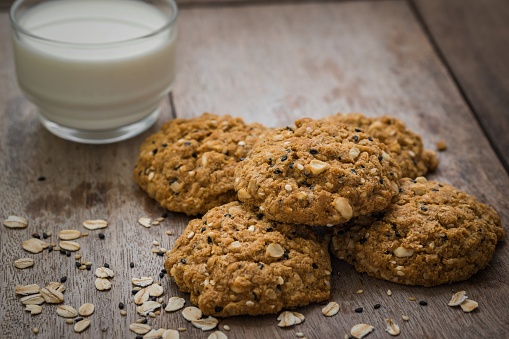 Oatmeal cookies with sesame seeds and glass of milk
