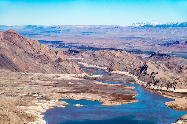 Lake Mead in Nevada, USA, close to the Grand Canyon national park. Lake Mead, when full, is the largest reservoir in the United States in terms of maximum water capacity. It is on the Colorado River about 39 km from the Las Vegas Strip southeast of the city of Las Vegas, Nevada, in the states of Nevada and Arizona. Formed by the Hoover Dam, Lake Mead is 180 km long when the lake is full, has 1,221 km of shoreline, is 162 m at greatest depth, with a surface elevation of 372.3 m above sea level, and has 640 km2 of surface, and when filled to available capacity, 32.22 km3 of water. However, the lake has not reached full capacity since 1983 due to a combination of drought and increased water demand. Owing to current low water level, Lake Sakakawea holds claim over Lake Mead in terms of America's largest reservoir by total area and water in reserve. The reservoir serves water to the states of Arizona, Nevada and California, providing sustenance to nearly 20 million people and large areas of farmland.
