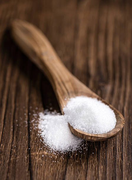istock White Sugar (selective focus) on wooden background 516329804