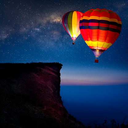 Hot air balloon flying over mountain at night