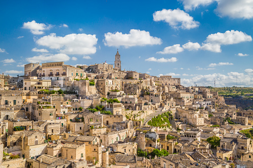 Ancient town of Matera (Sassi di Matera), European Capital of Culture 2019, in beautiful golden morning light at sunrise with blue sky and clouds, Basilicata, southern Italy.