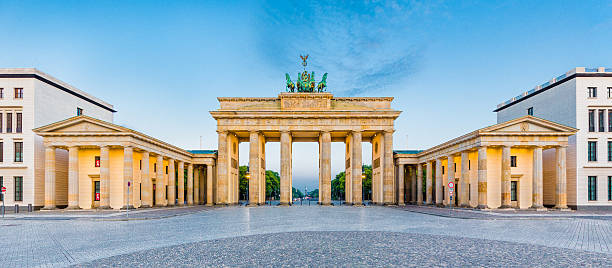 Brandenburg Gate panorama, Berlin, Germany Panoramic view of famous Brandenburger Tor (Brandenburg Gate), one of the best-known landmarks and national symbols of Germany, in beautiful golden morning light at sunrise, Pariser Platz, Berlin, Germany. east germany photos stock pictures, royalty-free photos & images