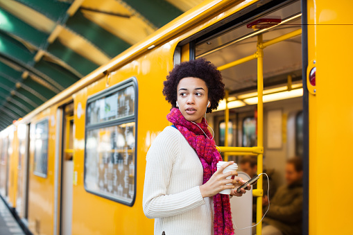 Portrait of young woman boarding a train at subway station