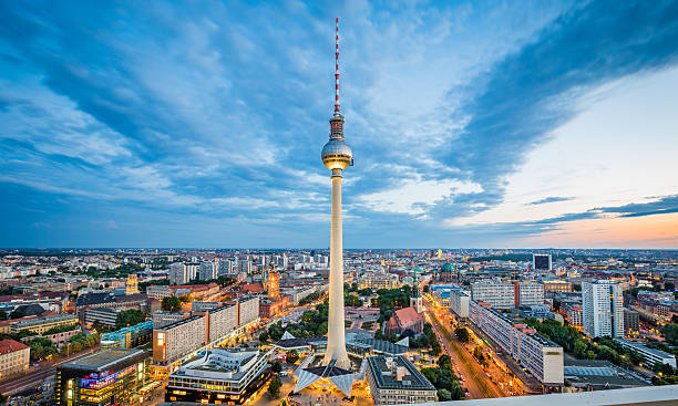 Berlin skyline panorama with TV tower at night, Germany Aerial view of Berlin skyline with famous TV tower at Alexanderplatz and dramatic cloudscape in twilight during blue hour at dusk, Germany. east berlin photos stock pictures, royalty-free photos & images