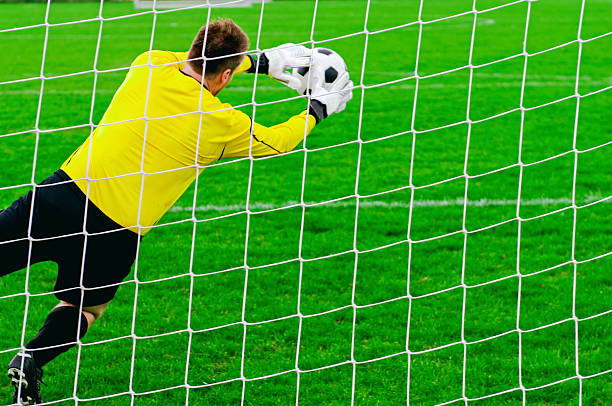 istock Goalkeeper defends goal by blocking a soccer ball 516331204