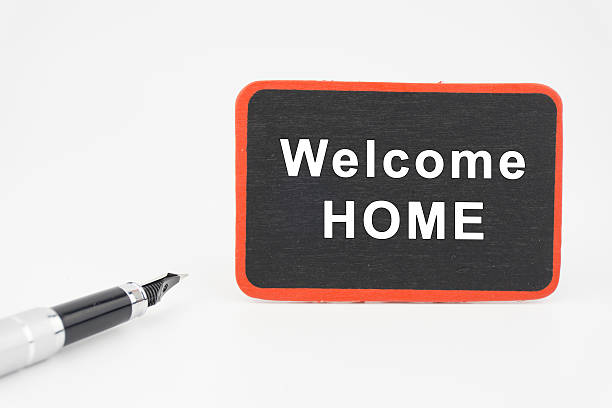Welcome HOME on mini blackboard  with pen over white background