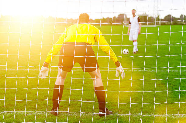 サッカー選手がボールから目を違約金スポット - football goal post goal post american football football field ストックフォトと画像