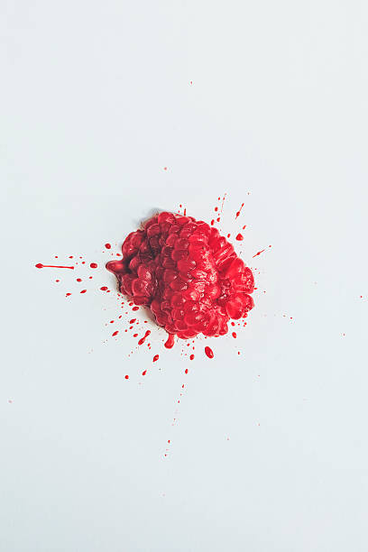 Raspberry Splattered A single bright red raspberry splattered on a white background raspberry photos stock pictures, royalty-free photos & images