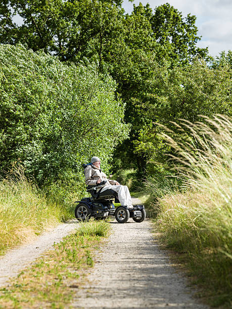 istock man in motorized wheelchair on dirt road 516332933