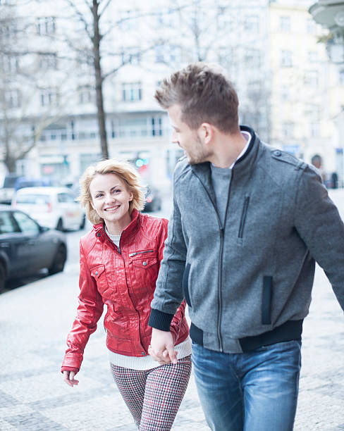 istock young couple holding hands while walking on city street 516333075