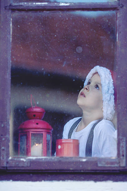 istock Adorable boy, looking through window, waiting for Santa 516334407