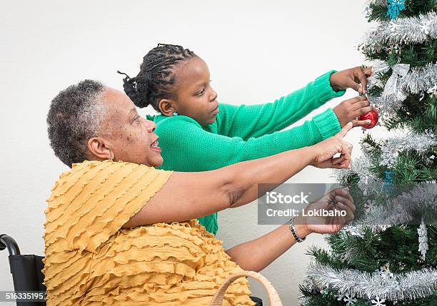 Enkelin Bei Großmutter Schmücken Weihnachtsbaum Stockfoto und mehr Bilder von Afrikanischer Abstammung - Afrikanischer Abstammung, Familie, Gelb