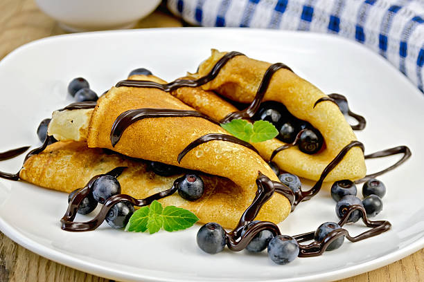 istock Pancakes with blueberries and chocolate syrup on the board 516336559