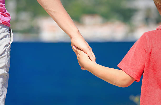 istock mother and kid holding hands on vacation 516336721