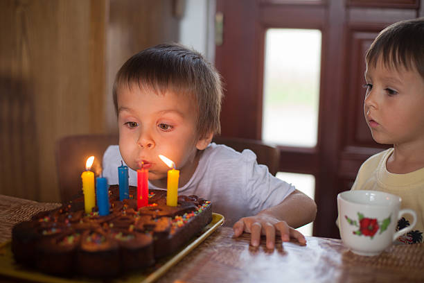 istock Adorable five year old boy celebrating his birthday and blowing 516336895