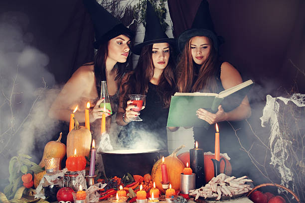 sorcières examiner le livre, teinté - color image halloween people elegance photos et images de collection