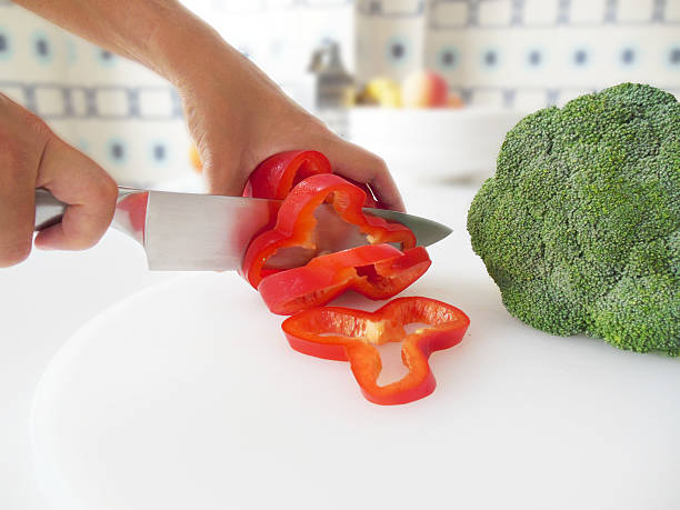 frau schneiden eine rote paprika. - cutting board cutting mat photography horizontal stock-fotos und bilder