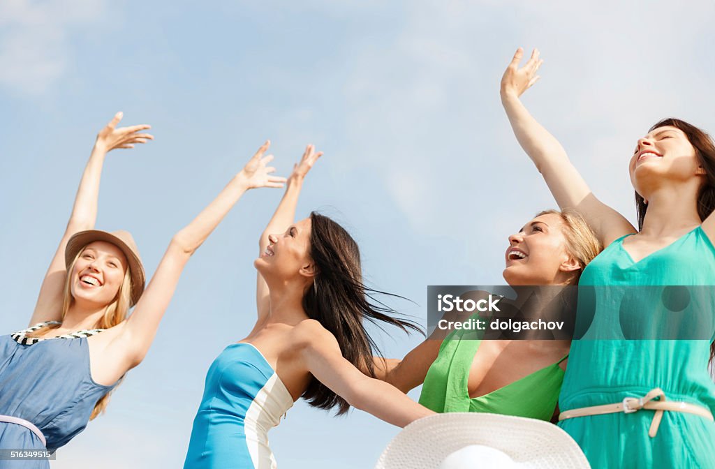 smiling girls with hands up on the beach summer holidays and vacation concept - smiling girls with hands up on the beach Beach Stock Photo