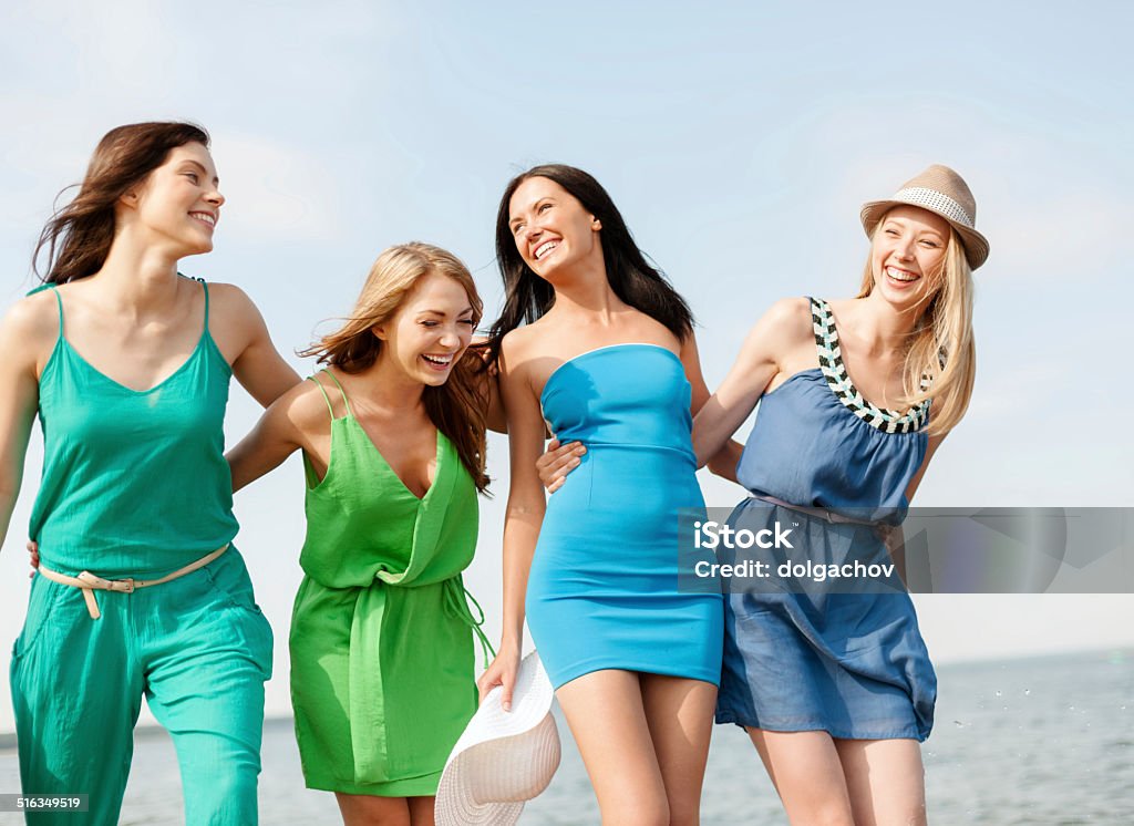 smiling girls walking on the beach summer holidays and vacation concept - smiling girls walking on the beach Dress Stock Photo