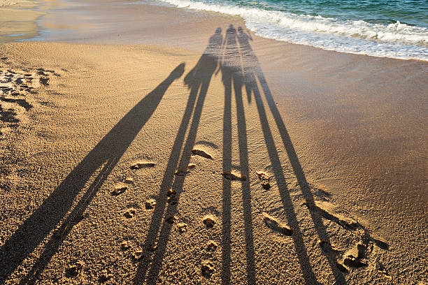 istock shadow of a family on the beach 516349815