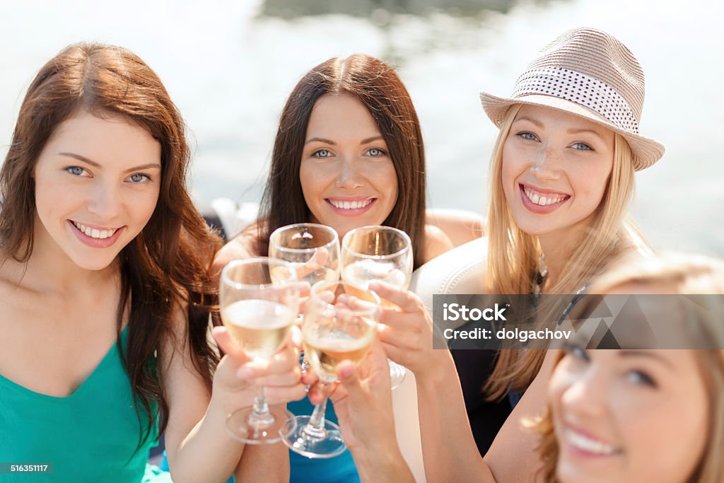 smiling girls with champagne glasses summer holidays, vacation and celebration concept - smiling girls with champagne glasses Party - Social Event Stock Photo