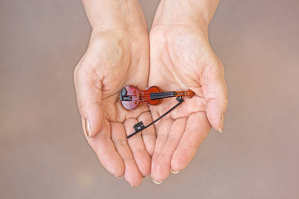 Small violin Violin on the woman's palm isolated mini violin stock pictures, royalty-free photos & images