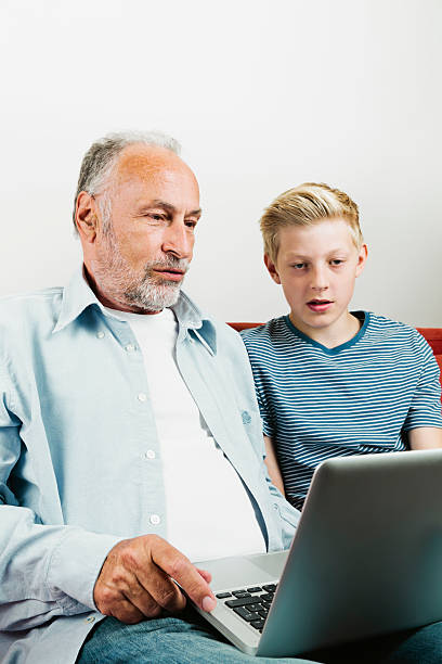 istock Grandson explaining grandfather how to use laptop 516352275
