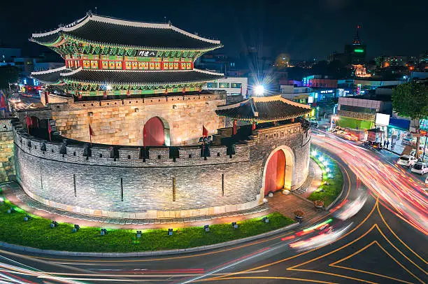 Late night traffic blurs past Paldalmun Gate in Suwon, South Korea.