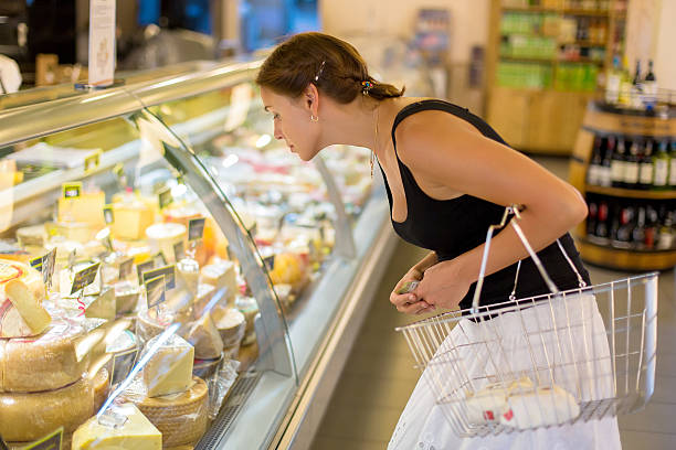 woman buys cheese in the supermarket woman buys cheese in the supermarket delicatessen stock pictures, royalty-free photos & images