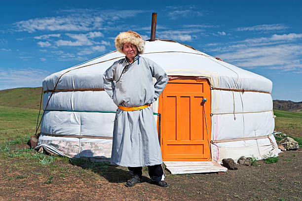 istock Mongolian man in national clothing standing next to ger 516356374