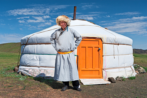 Mongolian man in national clothing standing next to ger (yurt). A yurt is a portable, felt-covered, wood lattice-framed dwelling structure traditionally used by nomads in the steppes of Central Asia. A yurt is more home-like than a tent in shape and build, with thicker walls. They are popular amongst nomads.http://bem.2be.pl/IS/mongolia_380.jpg