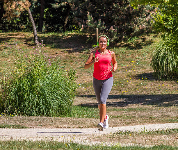 istock happy woman jogging and sweating on park path 516357878