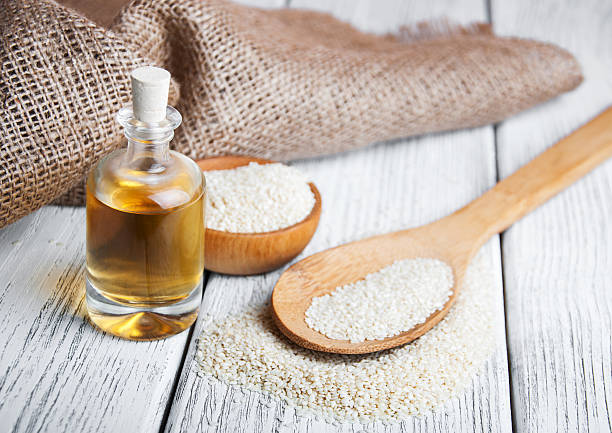 istock Sesame seeds and bottle with oil 516361216