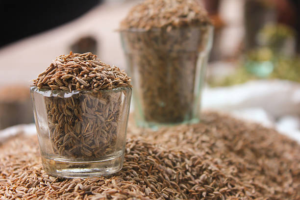 cumin seeds in glass at local market, indian spices Close-up view of glass filled with Cumin seeds, jeera cumin stock pictures, royalty-free photos & images