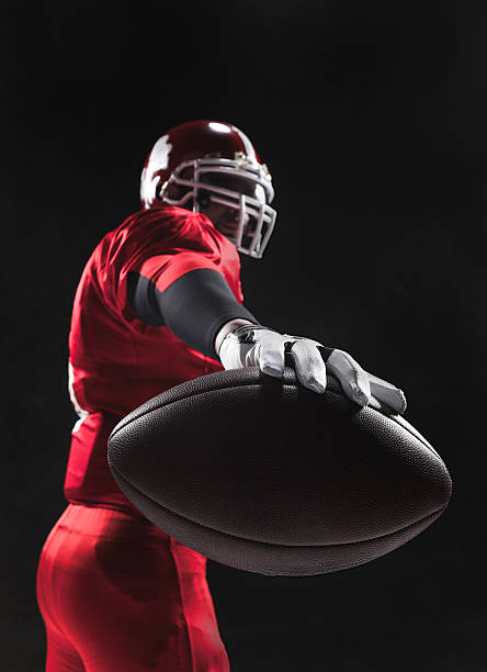 futebol americano posando com bola em fundo preto - football player american football athlete sport - fotografias e filmes do acervo