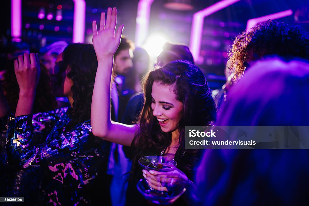 Jeune femme danse dans un club, avec un cocktail - Photo de Fête libre de droits