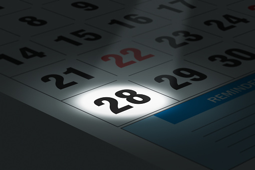 Illustration of calendar with a spot lit date in focus.