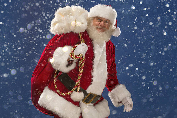 istock Real Santa Claus carrying gift bag in the snow 516373785