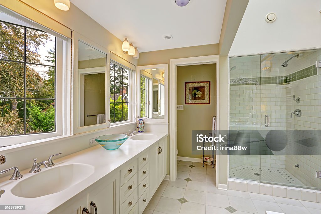 Spacious bright bathroom with glass door shower Spacious bright bathroom with white storage combination and glass door shower Apartment Stock Photo