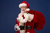 Real Santa Claus carrying gift bag