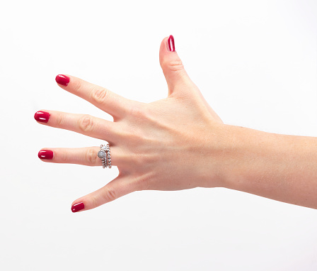 Young woman hand with painted nails and ring on white